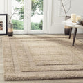 Beige area rug in a room with large windows and a table with candles.