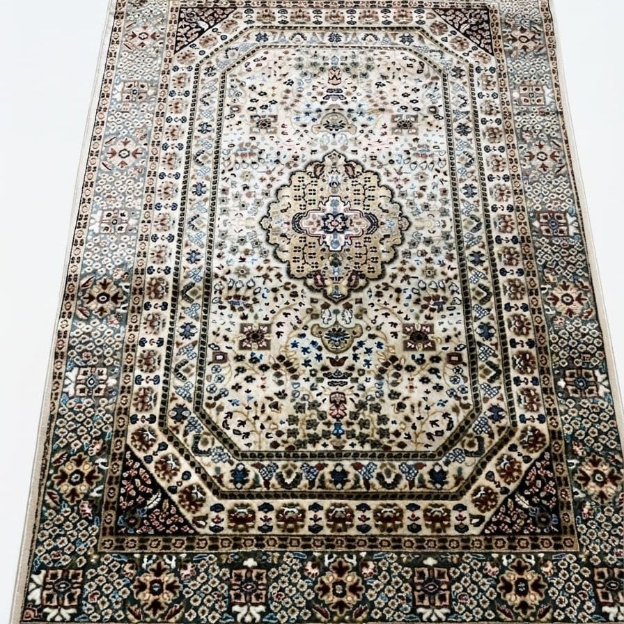A traditional oriental-style area rug with an intricate floral and geometric pattern, featuring a central medallion, detailed borders, and cream-colored fringe on the top and bottom edges.