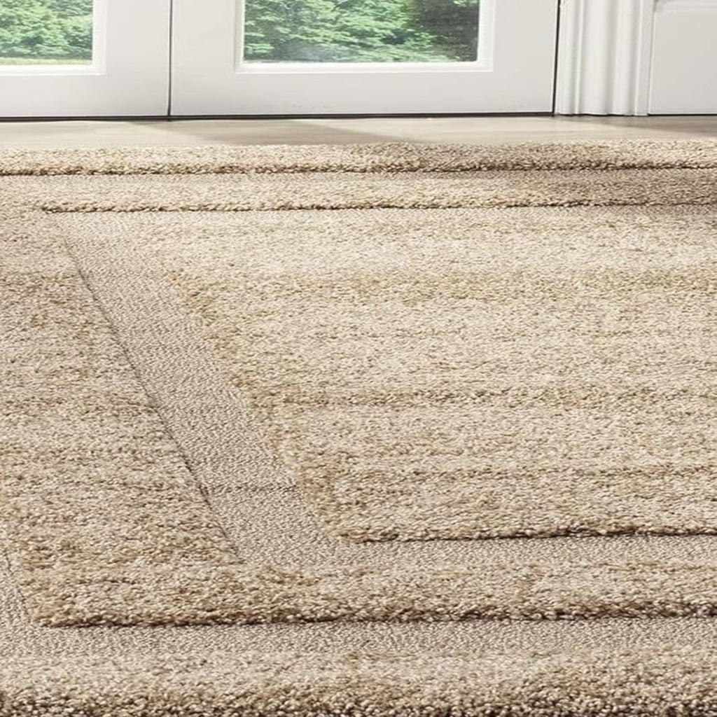 A close-up view of a shag area rug in a warm beige color, positioned on a light-colored floor in front of white glass doors.