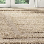 A close-up view of a shag area rug in a warm beige color, positioned on a light-colored floor in front of white glass doors.