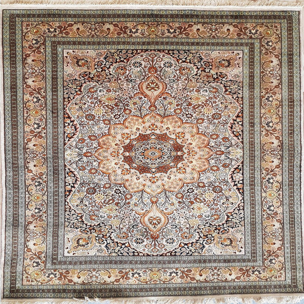 A square traditional area rug with an intricate floral and medallion pattern, featuring a central floral motif and a wide decorative border. The color palette is a warm mix of beige, brown, rust red, and muted blue, finished with white fringe on the top and bottom edges.
