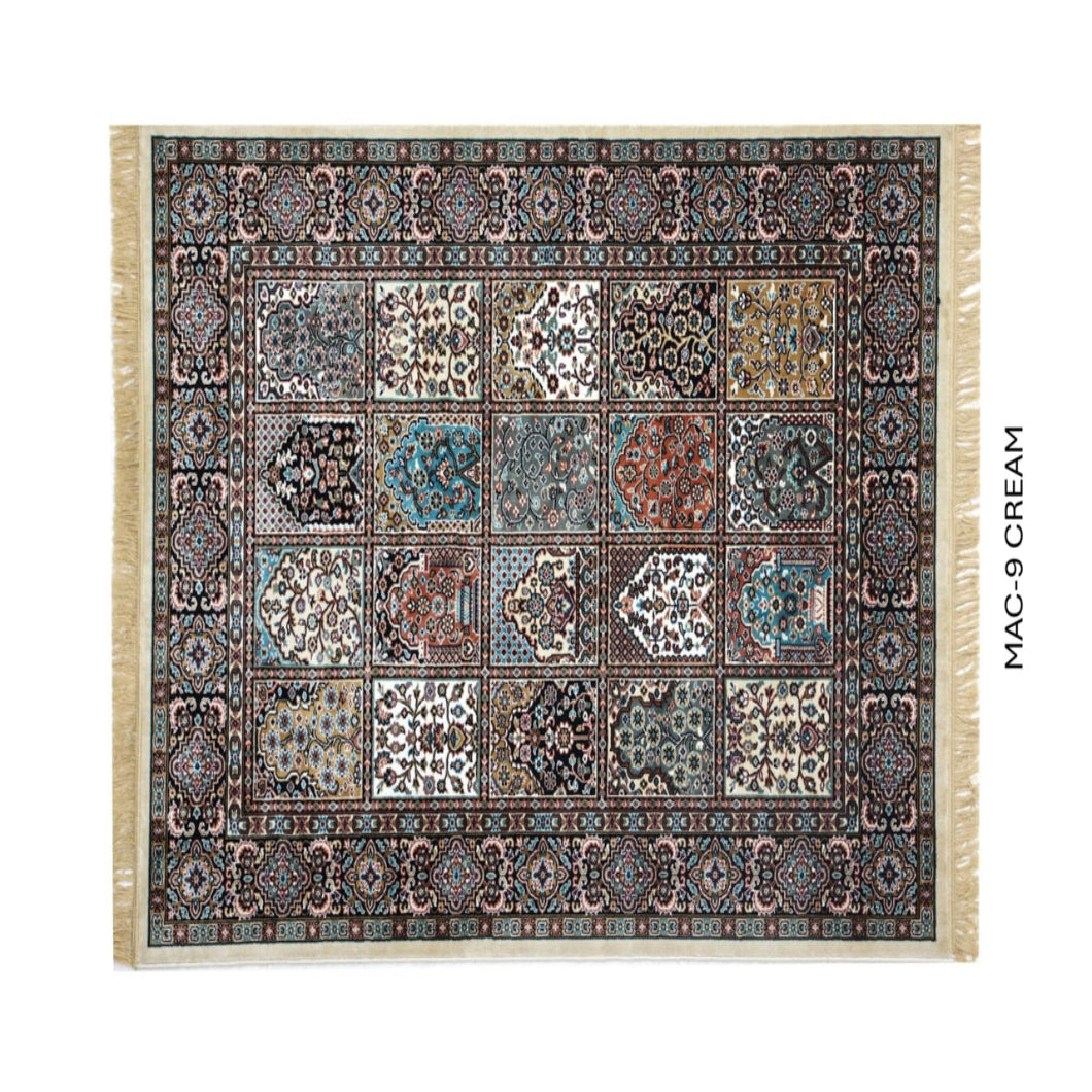 A rectangular patterned rug with cream fringe on all sides, shown flat against a white background. The rug features a complex traditional design with multiple panels in cream, blue, brown, and black.
